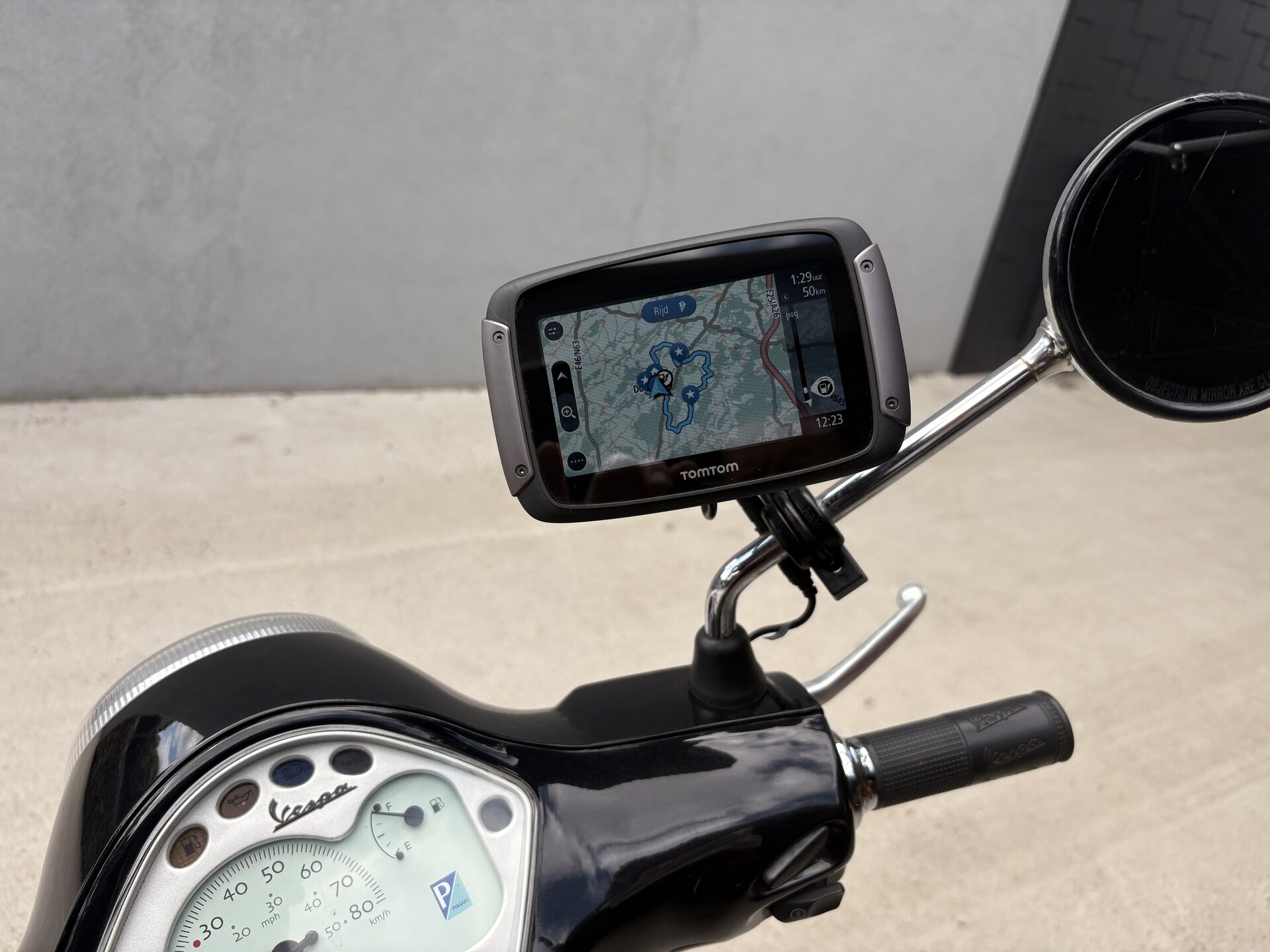 TomTom GPS met voorgeprogrammeerde routes op het stuur van een Vespa